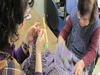 利用者とボランティアが編み物をしている写真