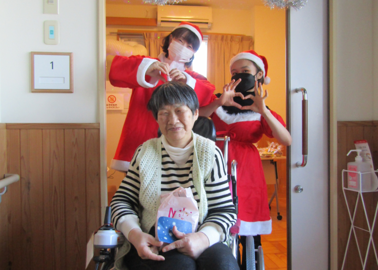 施設長が利用者さん生活支援員さんと一緒にクリスマス会を楽しんでいる写真