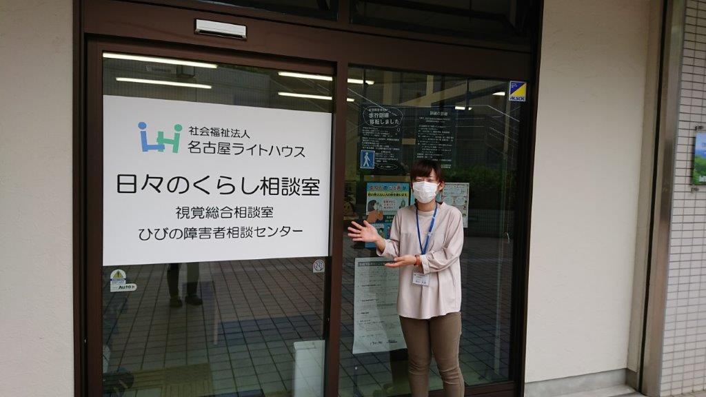 事業所の前で笑顔で笑う松山さんの写真