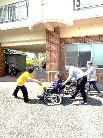 利用者の車椅子を押す職員と避難場所へと誘導する職員の写真