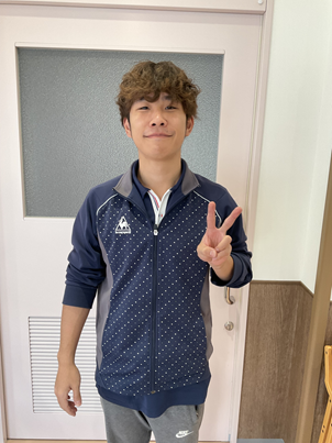 笑顔でピースをする澤田支援員