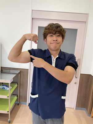 自慢の上腕二頭筋を披露する澤田支援員