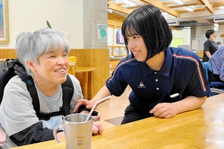 笑顔で利用者と談笑する右：横井支援員と左：利用者
