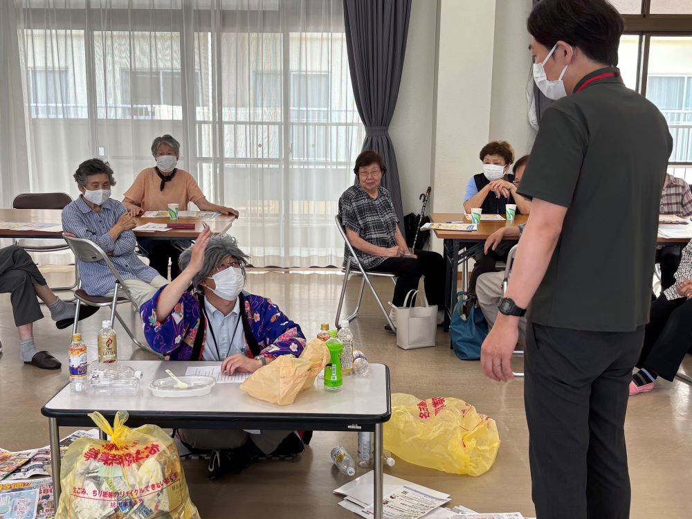 職員がおじいさんに変装して、いきいき支援センターの人と話している写真