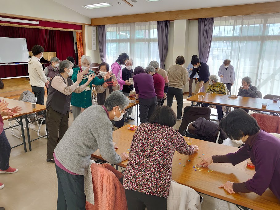 あやとりやけん玉、おはじきなどを参加者が楽しんでいる写真