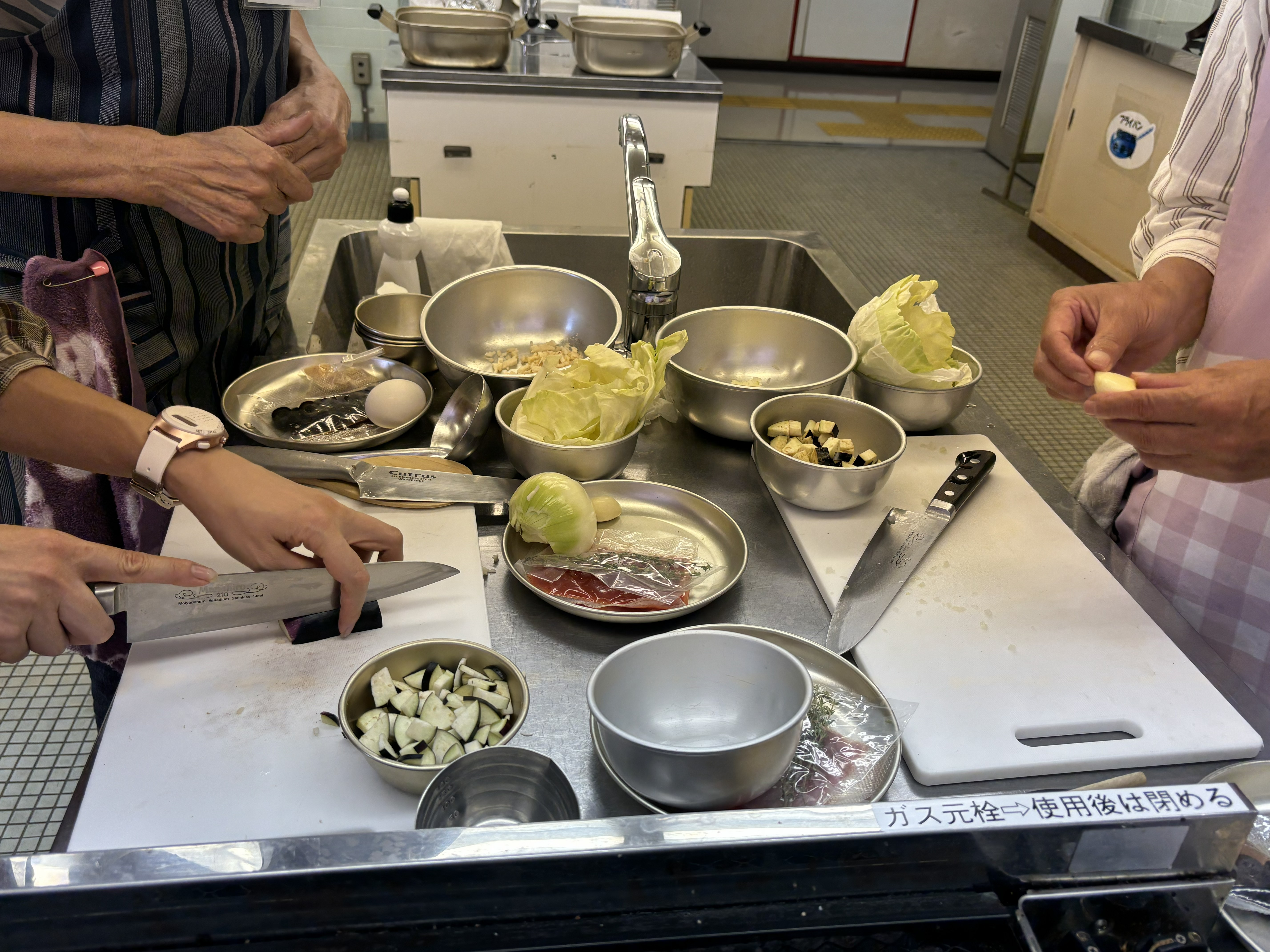 サポートボランティアと一緒にまな板で食材を切る写真