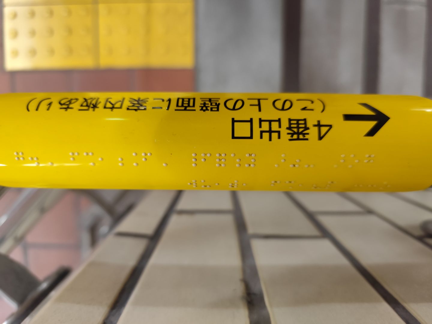 階段手すりに設置された点字サインの写真