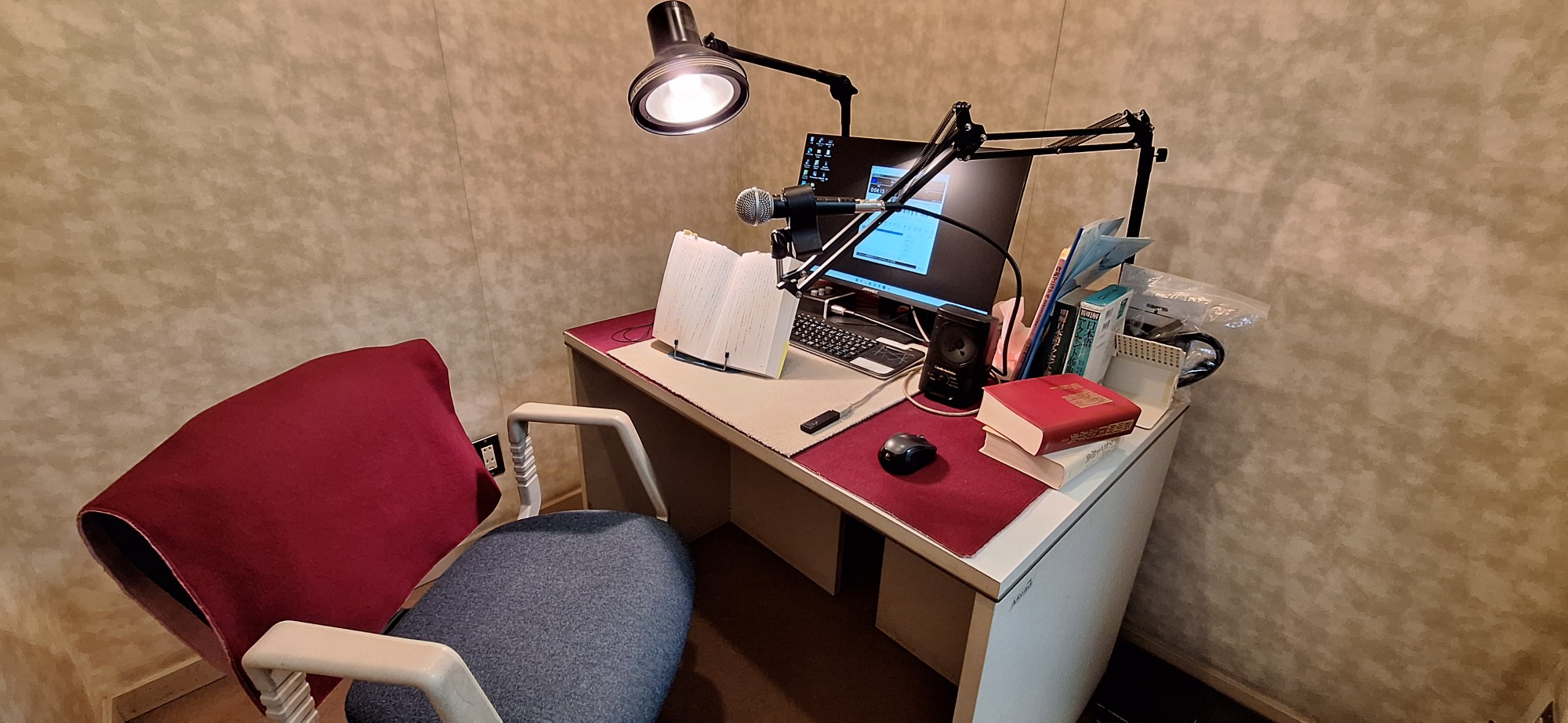 マイクとパソコンに向かい録音している写真